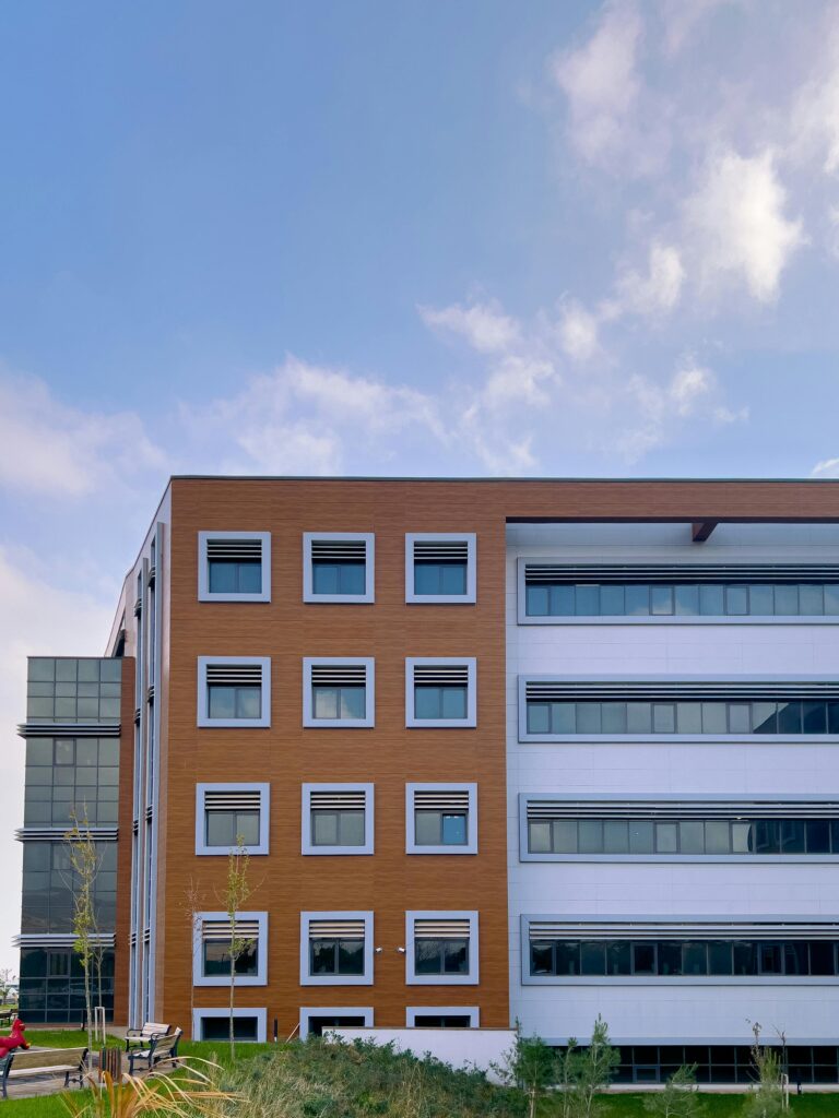 pexels-photo-14467554-14467554 A modern office building with a sleek glass facade and clear blue sky, showcasing contemporary architecture.